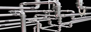 A maze of plumbing pipe, with one leaking water