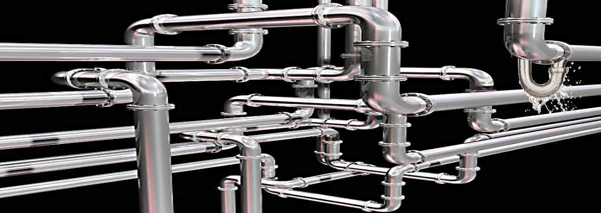 A maze of plumbing pipe, with one leaking water