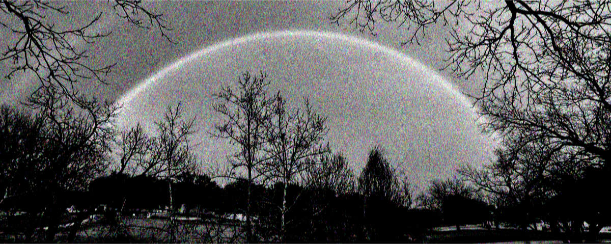 Photo: Grainy black and white photo of a double rainbow