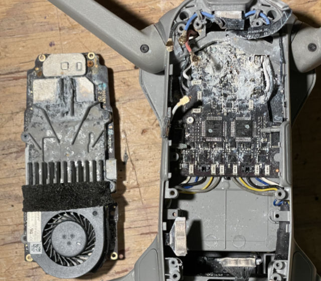 Photo: DJI Air 2s drone with bottom cover removed, showing damaged circuit board