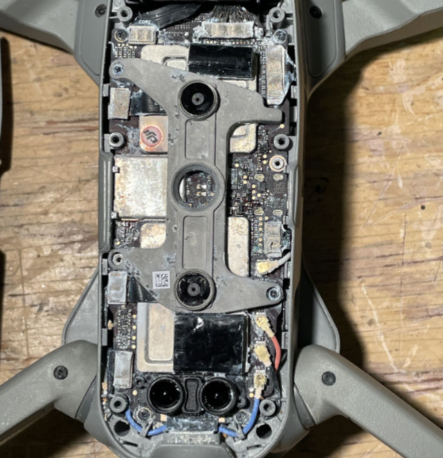 Photo: DJI Air 2s drone with bottom cover removed, showing damaged circuit board