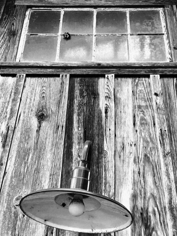 B&W photo: old wooden siding and light fixture, Greune, TX