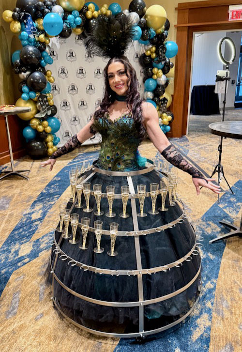 Photo: A young woman dressed in a hoop skirt that is designed to carry champagne flutes